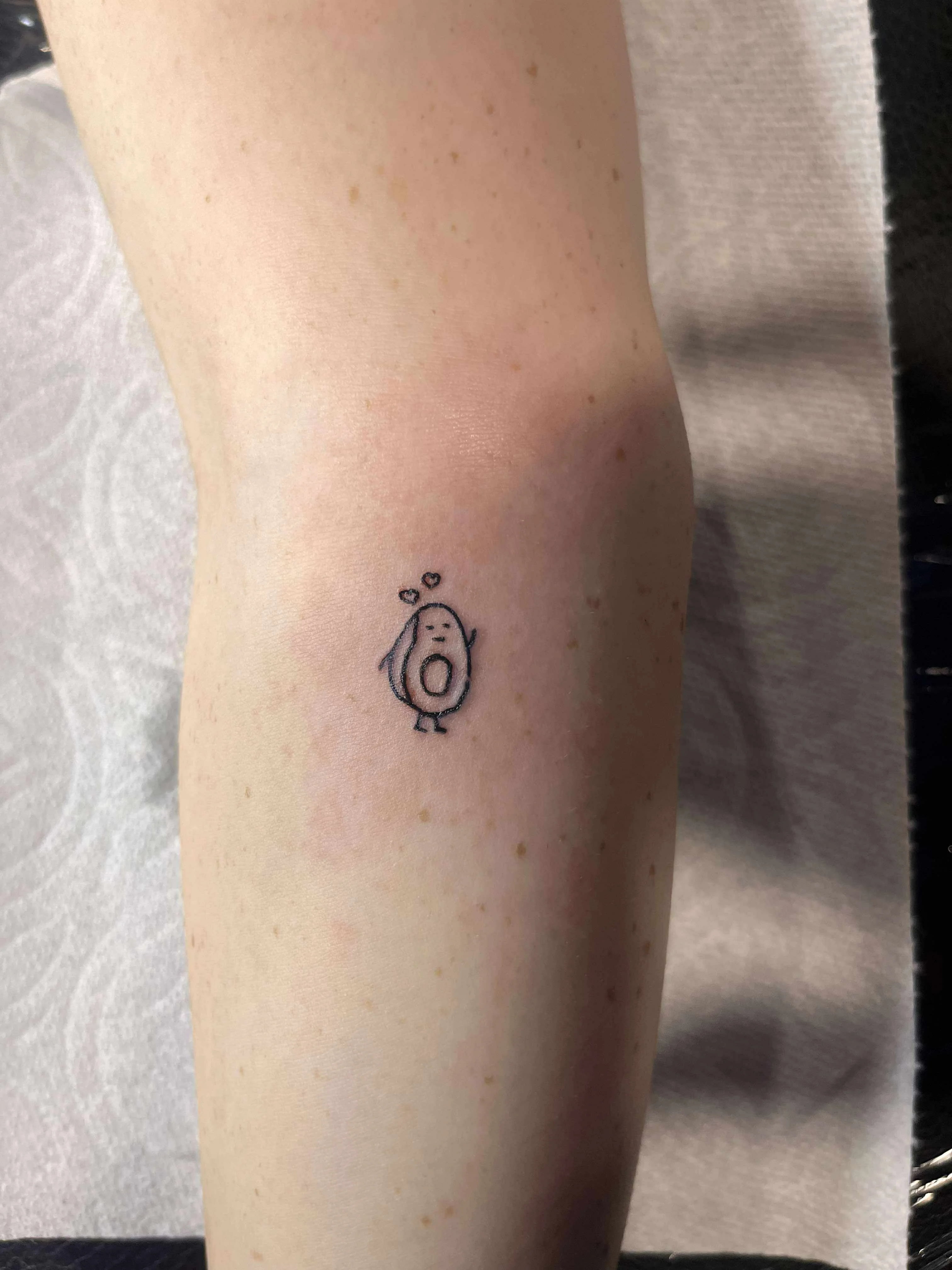 Fine line cute avocado character tattoo with kawaii style and minimal linework