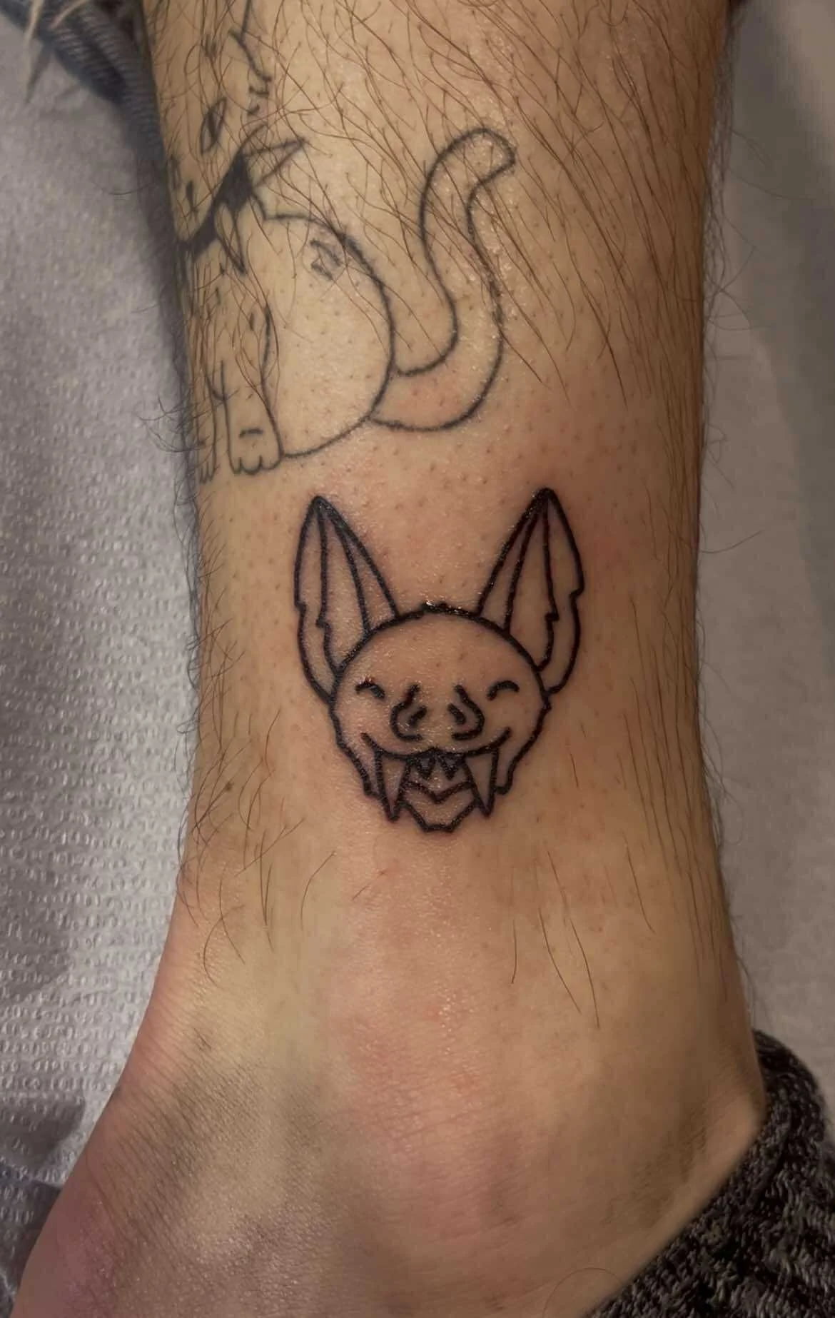 Fine line cute bat and ghost tattoo with adorable Halloween-themed design