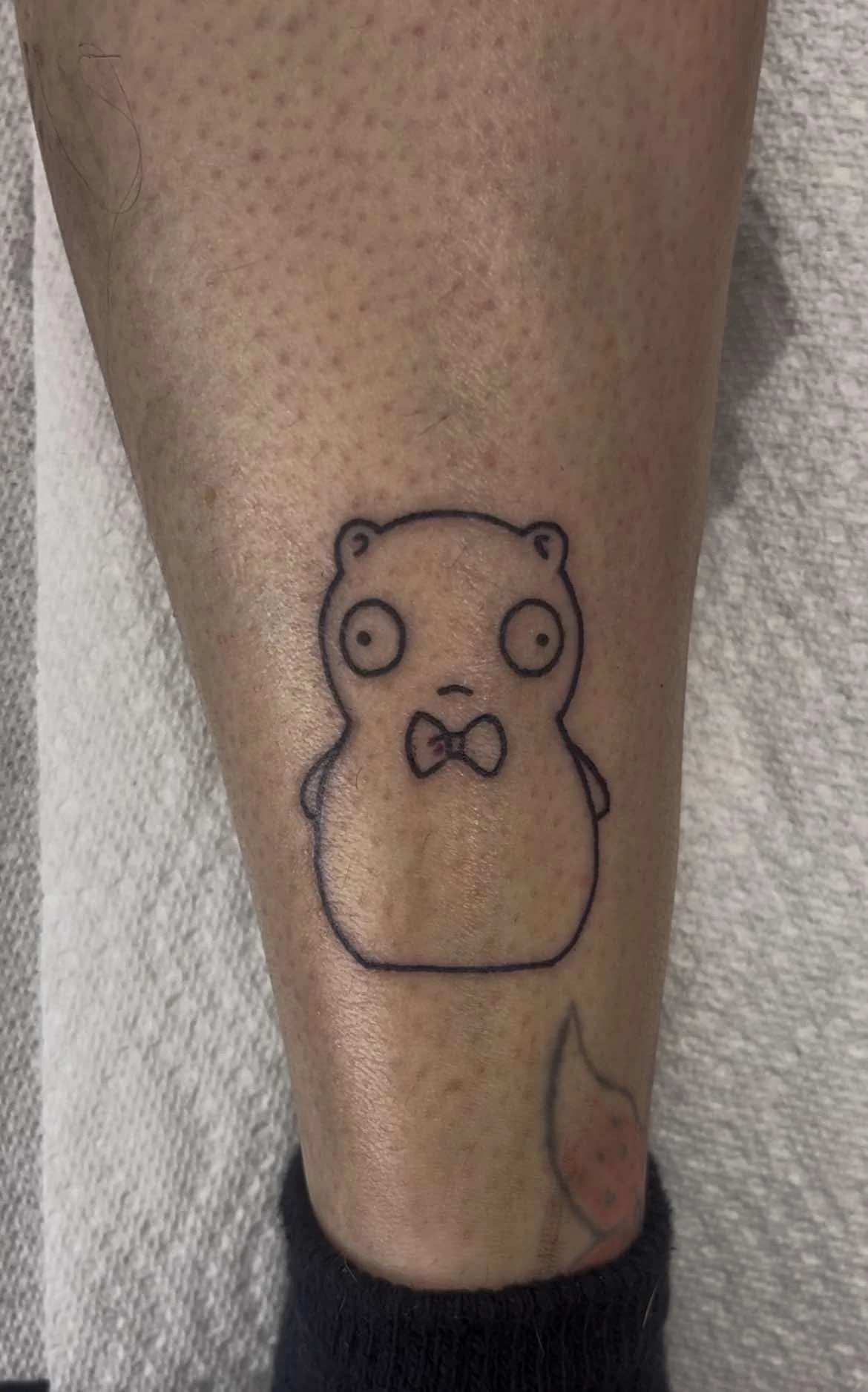 Fine line cute bear tattoo with bow tie and adorable expression