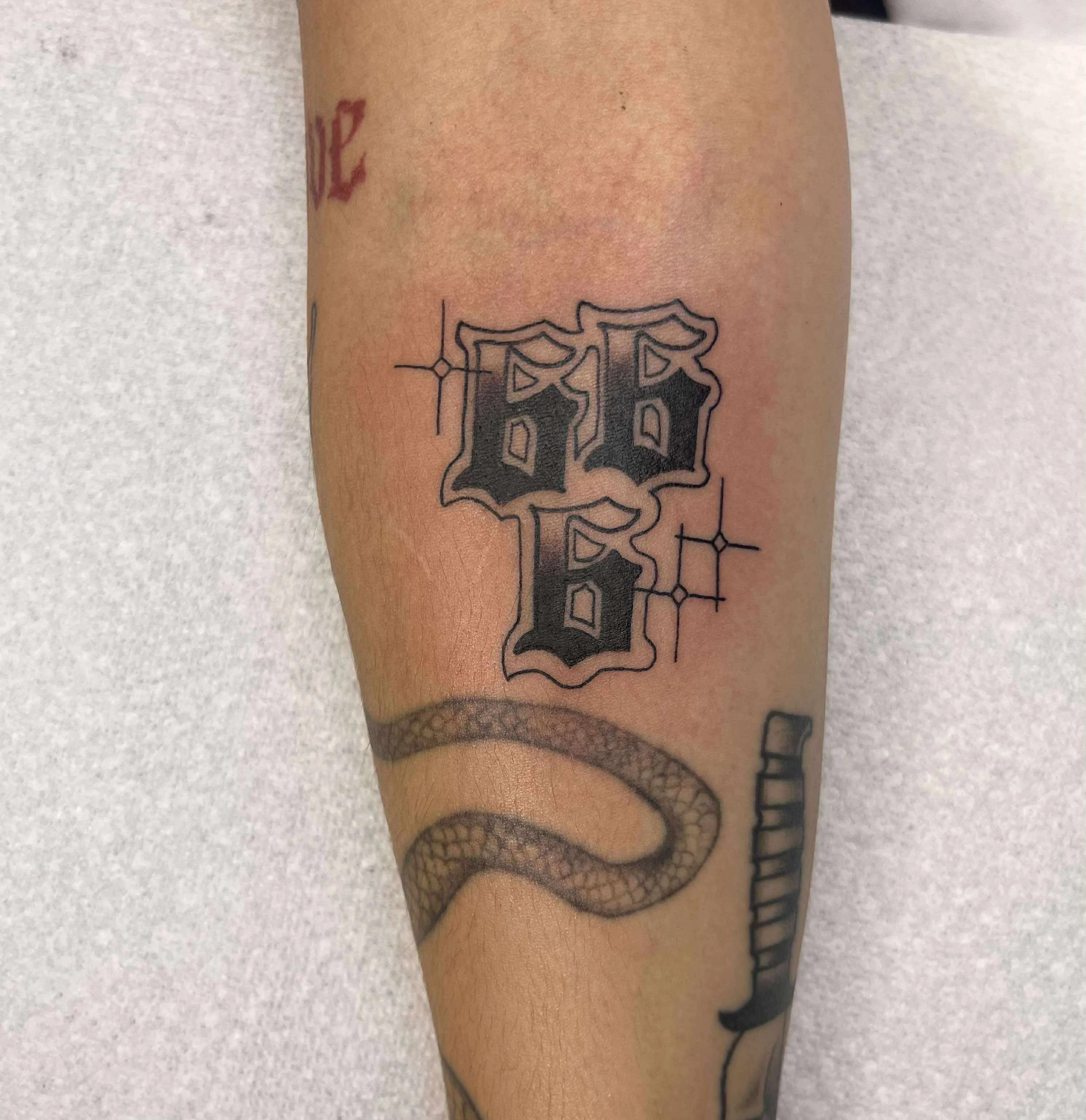 Fine line gothic letter P tattoo with ornate lettering and decorative styling