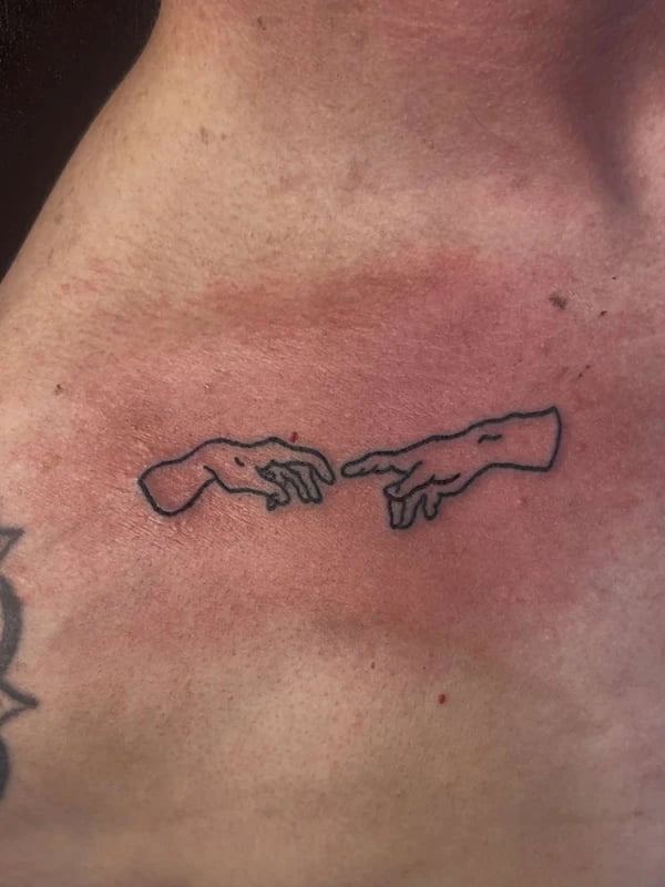 Fine line hands tattoo with detailed finger work and delicate shading