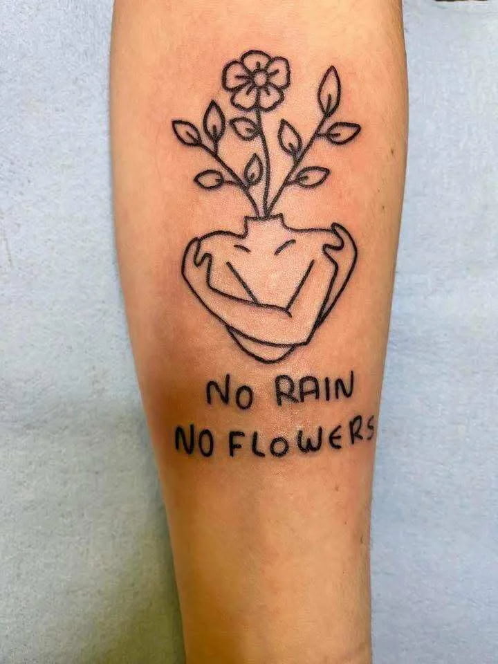 Fine line heart with flower and quote tattoo with delicate script and floral details