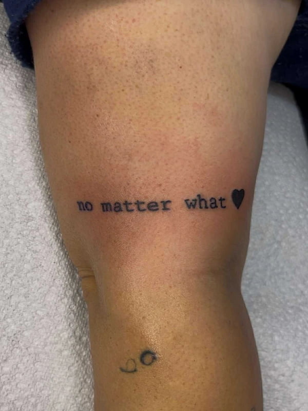 Fine line script tattoo reading "No Matter What" with delicate lettering