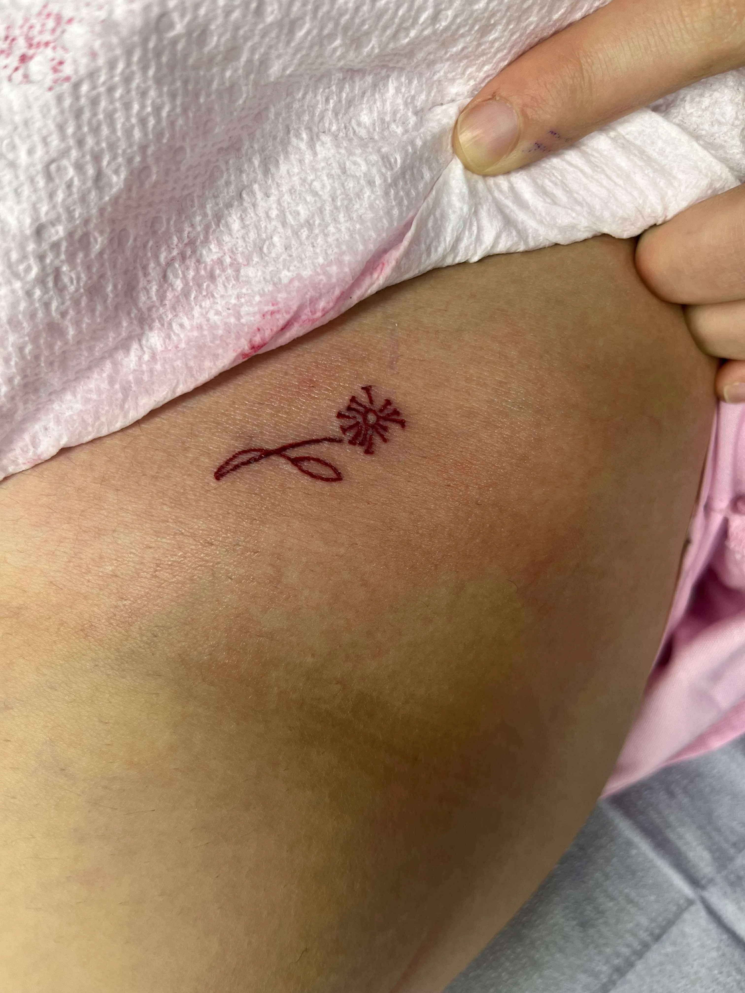 Fine line small daisy tattoo with minimal design and simple botanical styling