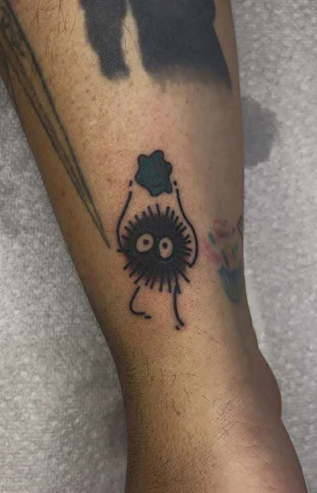 Fine line soot sprite tattoo inspired by Studio Ghibli with cute character design