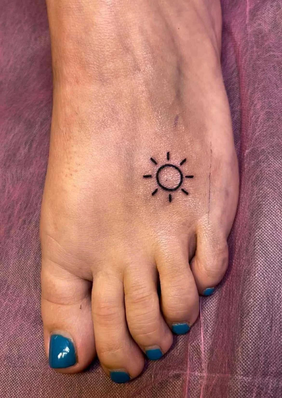Fine line simple sun tattoo with minimalist rays and clean geometric design