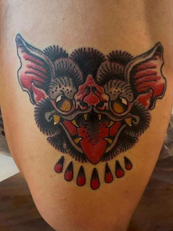 Traditional bat tattoo with heart-shaped body and blood drops in classic style