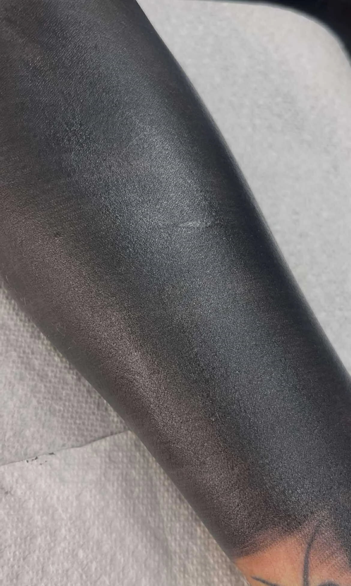Traditional blackout sleeve tattoo with solid black coverage