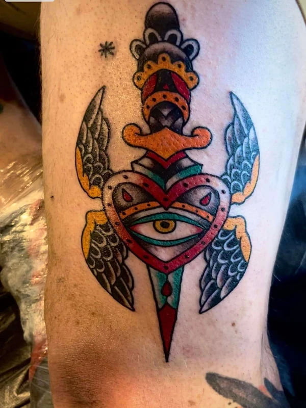 Traditional dagger through eye tattoo with classic American traditional elements