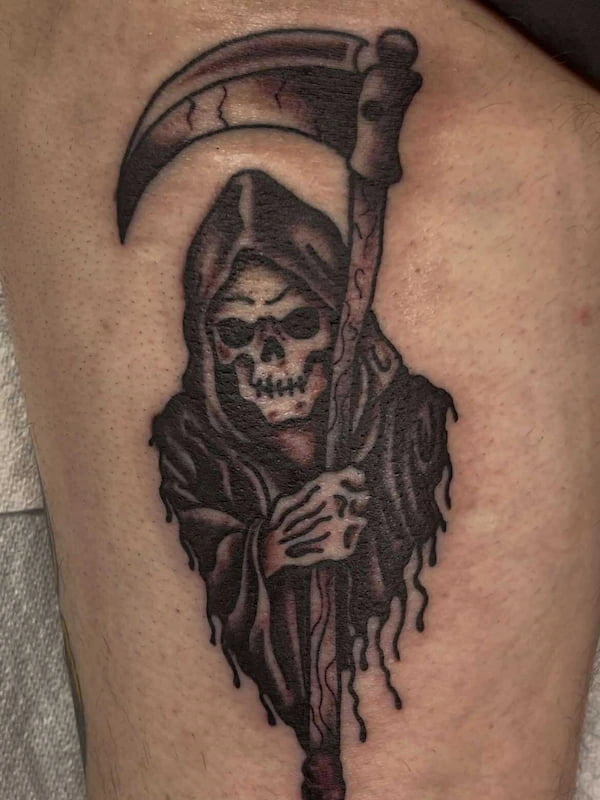 Traditional grim reaper tattoo with scythe and classic death imagery