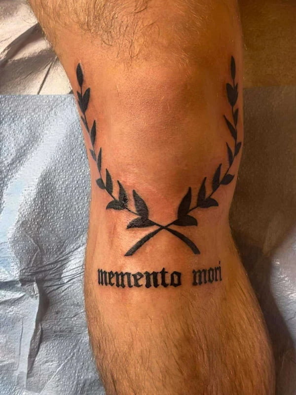 Traditional memento mori tattoo with laurel wreath and Latin text