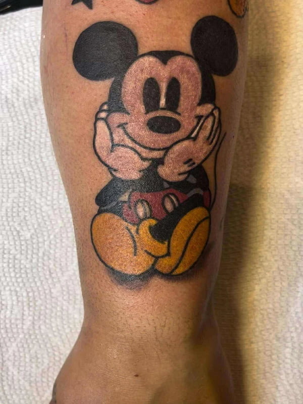 Traditional style Mickey Mouse tattoo with classic cartoon character in bold traditional design