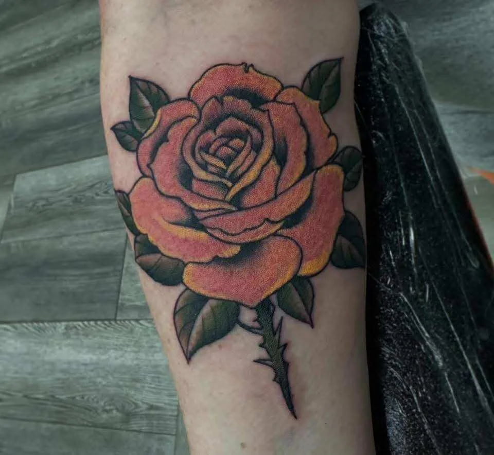 Traditional orange rose tattoo with bold colors and classic American traditional design