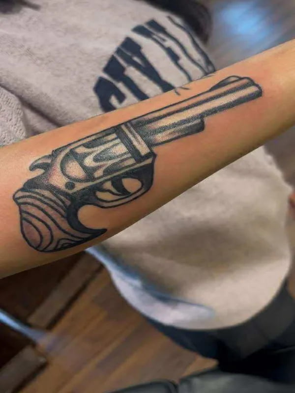 Traditional revolver pistol tattoo with classic American traditional styling