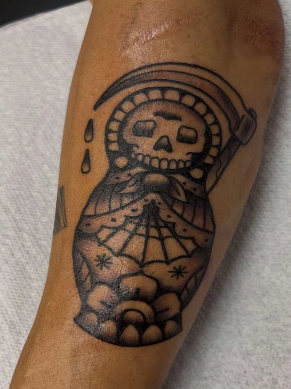 Traditional grim reaper skull with hourglass tattoo in classic American traditional style