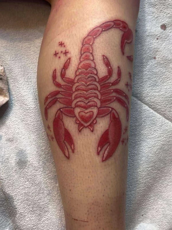 Traditional red scorpion tattoo with heart details and star accents
