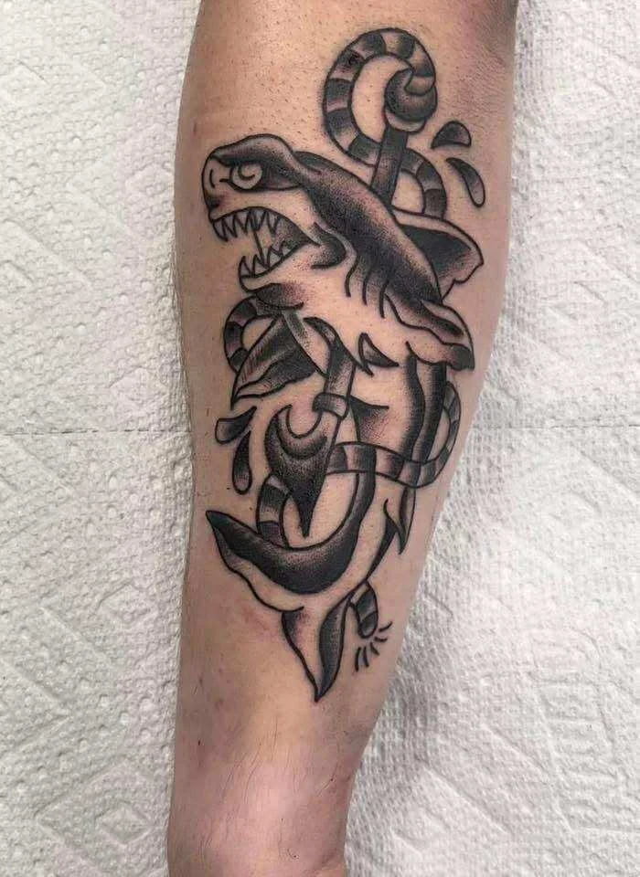 Traditional shark with dagger tattoo in classic American traditional style
