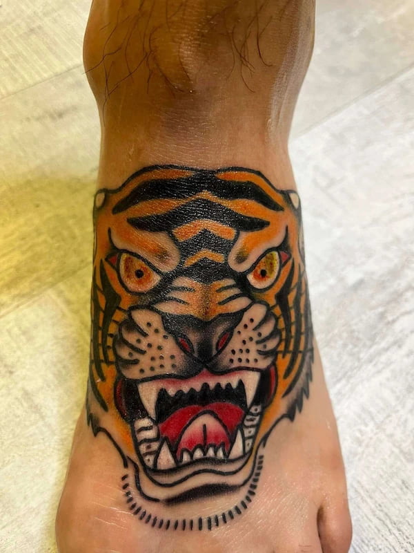 Traditional tiger head tattoo with fierce expression and bold traditional colors