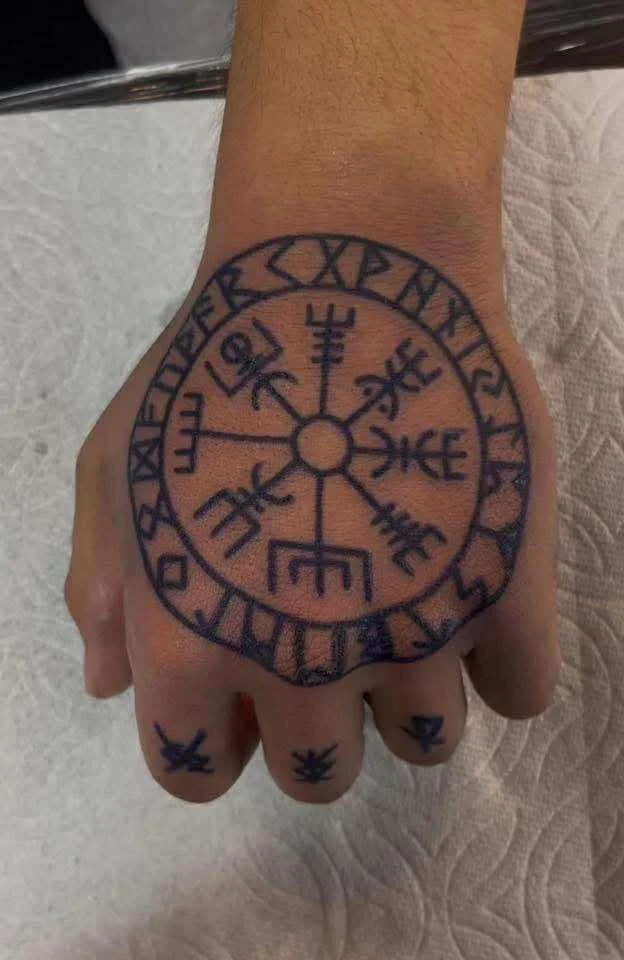 Traditional Viking compass tattoo on hand with Norse navigation symbol