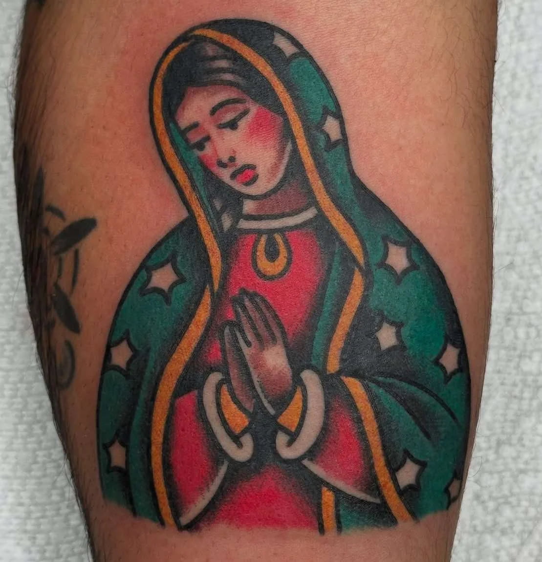 Traditional Virgin Mary religious tattoo with praying hands and sacred imagery