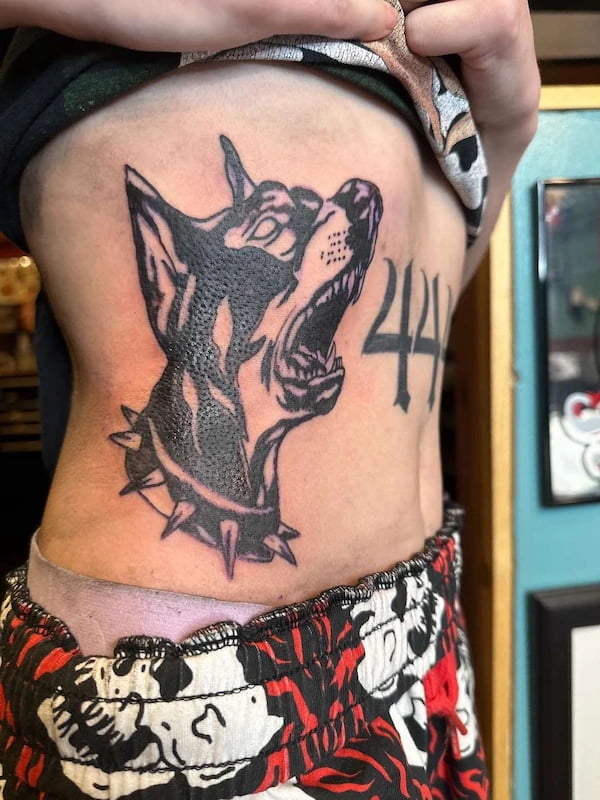 Traditional fierce wolf head tattoo with spiked collar and bold linework